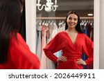 Woman trying on dress in clothing rental salon