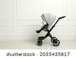 Baby carriage. Modern pram near white wall, space for text