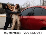 Small photo of Woman defending herself from attacker near car outdoors