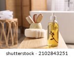 Dispenser with liquid soap on wooden table in bathroom, space for text