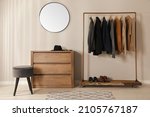 Modern dressing room interior with stylish clothes, shoes and mirror