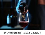 Bartender pouring red wine from ...