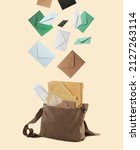 Small photo of Many different envelopes falling into brown postman's bag on beige background