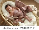 Small photo of Cute newborn baby with pacifier and toy bunny lying in cradle at home, top view