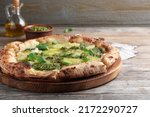 Delicious pizza with pesto, cheese and basil on wooden table