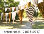 Golden bunting flags in park. Party decor