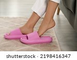 Woman putting on pink slippers...