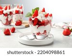 Delicious strawberries with whipped cream served on light grey table