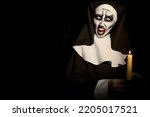 Small photo of Scary devilish nun with burning candle on black background, space for text. Halloween party look