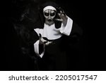 Small photo of Portrait of scary devilish nun on black background. Halloween party look