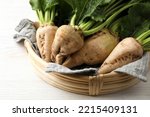 Basket with fresh sugar beets on white wooden table, closeup