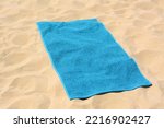 Beautiful soft blue towel on sandy beach