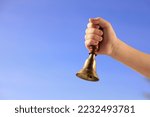 Pupil with school bell against...