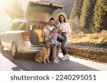 Parents, their daughter and dog near car outdoors. Family traveling with pet