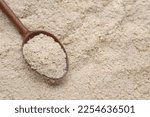 Small photo of Wooden spoon of brewer`s yeast on flakes, top view