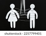 Divorce concept. Paper human figures with white thread and scissors on black background, flat lay