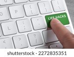 Woman pressing green button with words Life Hacks on computer keyboard, closeup
