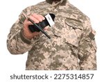 Small photo of Soldier in military uniform holding medical tourniquet on white background, closeup