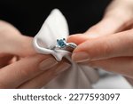 Small photo of Jeweler cleaning topaz ring with microfiber cloth, closeup