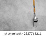 Small photo of One metal whistle with cord on light grey table, top view. Space for text
