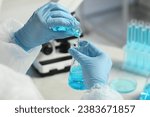 Small photo of Scientist working with flasks in laboratory, closeup