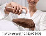 Small photo of Self-tanning. Woman applying cosmetic product onto tanning mitt indoors, closeup