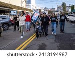 Small photo of AUBURN, CA, U.S.A. - JAN. 15, 2024: Rapper Unity Lewis leads marchers with signs on Lincoln Way in the downtown area as part of a Dr. Martin Luther King, Jr. holiday event in this small community.