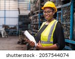 Engineers or technicians are inspecting auto parts in warehouses and factories. African american woman holding a flipchart in parts warehouse.