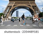 Small photo of Illustration picture shows people using self-service electric scooters (here a E-scooter of the company DOTT) with the Eiffel Tower in the background in streets of Paris, France on August 8, 2023.