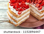 Taking of delicious strawberry cake from plate by using shovel, closeup
