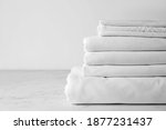 Stack of clean bed sheets on table