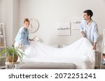 Young couple making their bed