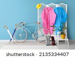 Small photo of Folding screen with raincoats, gumboots, umbrellas and bicycle in hallway