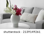 Vase with beautiful hyacinth flowers on table in living room