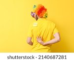 Funny man in disguise and with sticky note on his back against yellow background. April fools' day celebration