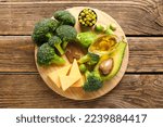 Small photo of Board with healthy products and letter K on wooden background