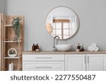 Interior of light bathroom with counters, sink and mirror