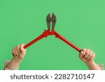 Worker with bolt cutter on green background