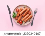 Plate with tasty grilled sausages on pink background