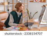 Female graphic designer working with computer at table in office