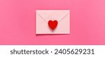 Envelope and red heart on pink...