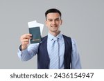 Small photo of Handsome steward with passport on light background