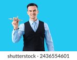 Small photo of Handsome steward with wooden airplane on blue background