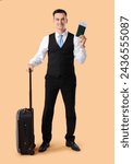 Small photo of Handsome steward with suitcase and passport on beige background