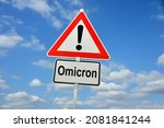 Small photo of Hamburg, Germany - November 27, 2021: German Traffic warning sign with the note Omicron - symbolizes the danger from a new variant named Omicron
