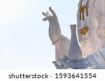 hand of Lady buddha in temple,Bodhisattva statue in sky background. image of white bodhisattva statue in blue sky background.