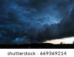 Summer landscape with black storm clouds in the sunset sky