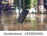  Smartphone falling and crashing on wet ground in the city park on a rainy day. accident with smartphone