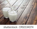 Two Glasses With Pouring Milk...