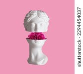Small photo of Female antique statue's head with pink flowers roses in the cut isolated on a color background. The beauty inside. Trendy collage in magazine surreal style. 3d contemporary art. Modern design